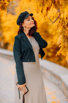 A woman walks outdoors in autumn, enjoys the autumn weather