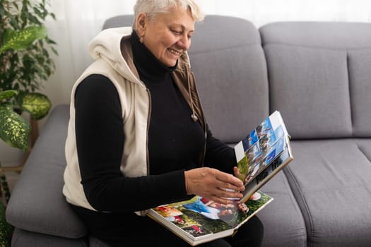 senior woman holding a family photo album, photo book.