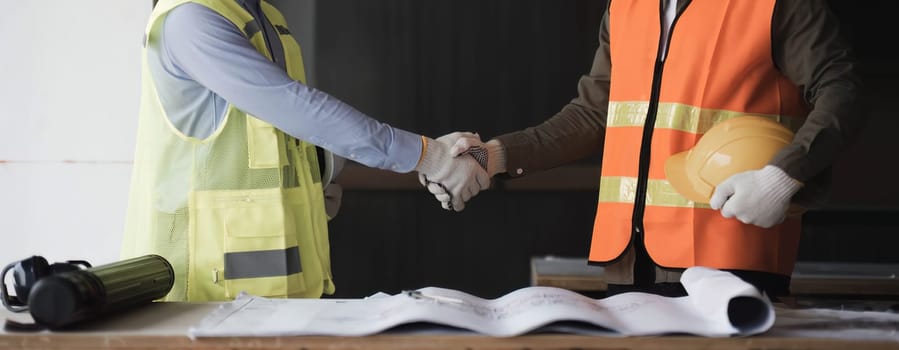 Businessman handshake with engineering in construction renovate building site. Engineer or architect inspection workplace for project.Teamwork construction engineer,business and architecture concept