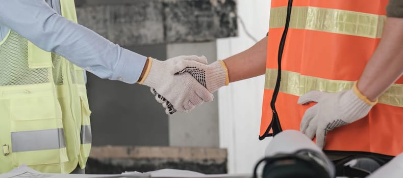Businessman handshake with engineering in construction renovate building site. Engineer or architect inspection workplace for project.Teamwork construction engineer,business and architecture concept