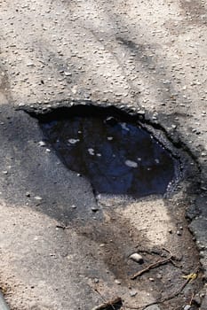 Hole in the pavement on the road close up
