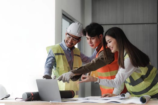 Engineers work as a team with blueprints for architectural plans. Engineer sketching construction project concept with architect equipment Architects talking at table Teamwork and construction concept.