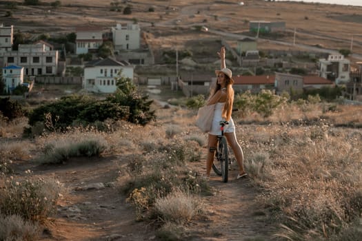 A woman cyclist on a mountain bike looking at the landscape sea. Adventure travel on bike