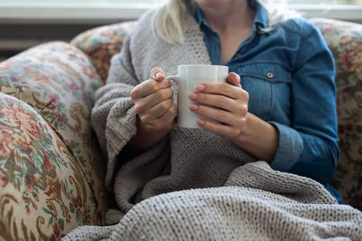 warm cup of hot coffee warming in the hands of a girl