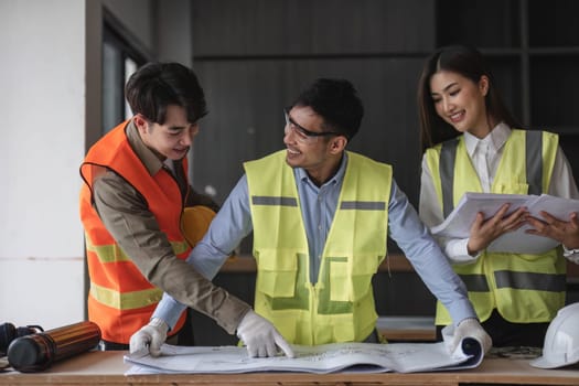 Engineers work as a team with blueprints for architectural plans. Engineer sketching construction project concept with architect equipment Architects talking at table Teamwork and construction concept.