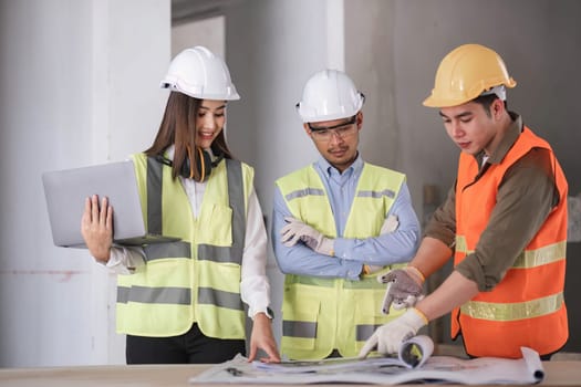 Engineers work as a team with blueprints for architectural plans. Engineer sketching construction project concept with architect equipment Architects talking at table Teamwork and construction concept.