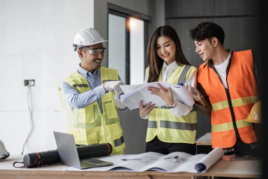 Engineers work as a team with blueprints for architectural plans. Engineer sketching construction project concept with architect equipment Architects talking at table Teamwork and construction concept.