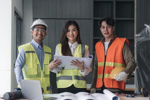 Engineers work as a team with blueprints for architectural plans. Engineer sketching construction project concept with architect equipment Architects talking at table Teamwork and construction concept.