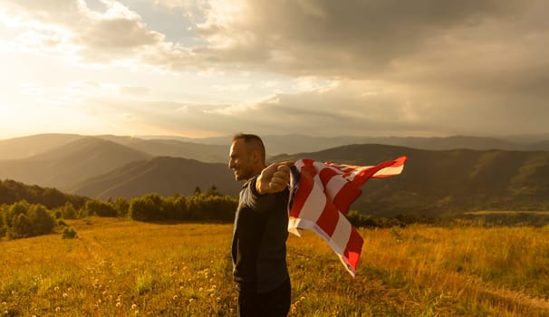 successful silhouette man winner waving American flag on top of the mountain.