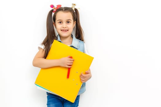 happy sweet little school girl carrying schoolbag backpack and books smiling in education and back to school concept isolated on white background