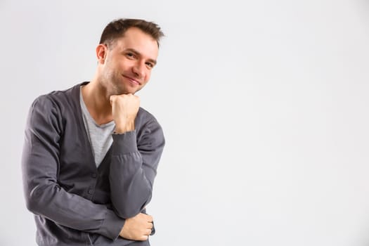 portrait emotional man standing near a wall on a gray background