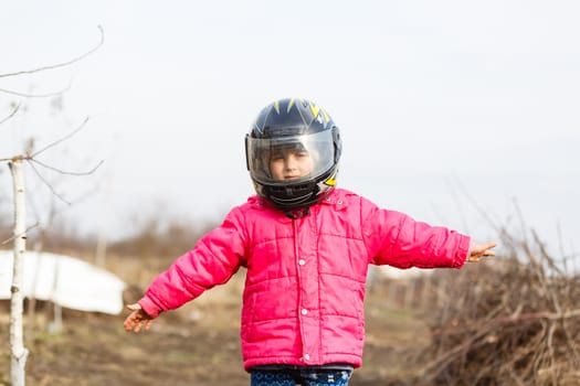 portrait of a little girl smiling in a protective helmet female child in motocross moto helmet. biker girl in motocross helmet.