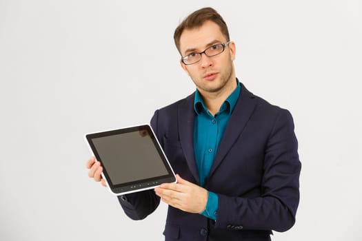 Portrait of a serious businessman holding tablet computer and looking at camera isolated on a white background