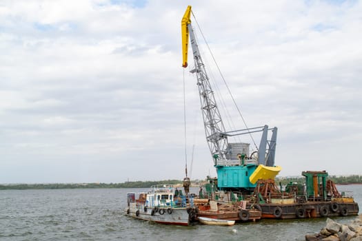 Luffing crane at the barge on water. High quality photo