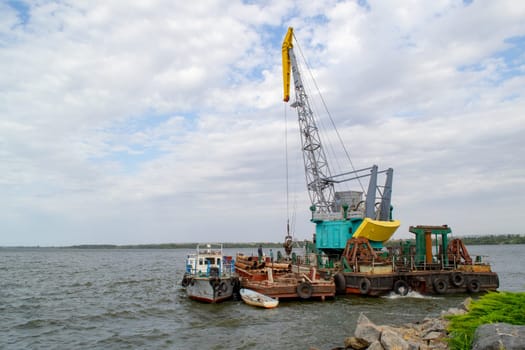 Luffing crane at the barge on water. High quality photo