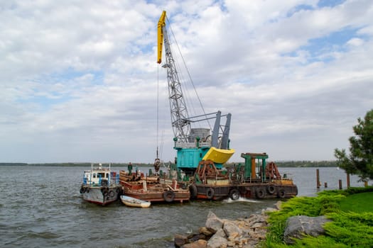 Luffing crane at the barge on water. High quality photo