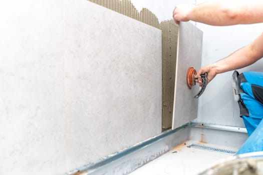 craftsman tiling the room with large format tiling. High quality photo