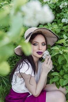 A fashionable girl with dark hair, a spring portrait in lilac tones in summer. Bright professional makeup