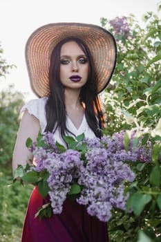 A fashionable girl with dark hair, a spring portrait in lilac tones in summer. Bright professional makeup