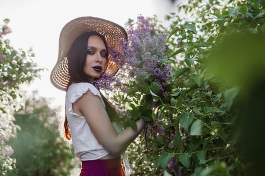 A fashionable girl with dark hair, a spring portrait in lilac tones in summer. Bright professional makeup