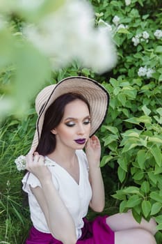 A fashionable girl with dark hair, a spring portrait in lilac tones in summer. Bright professional makeup