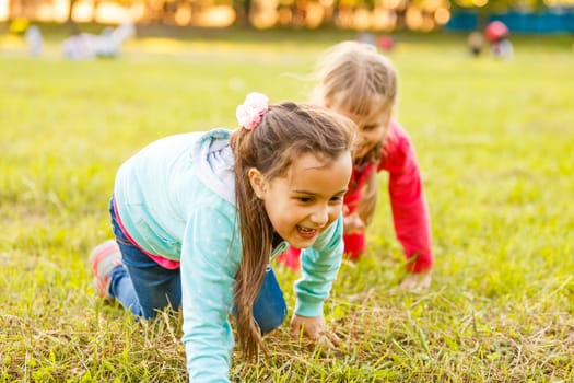 Adorable little girls having fun playing outdoors on summer day.