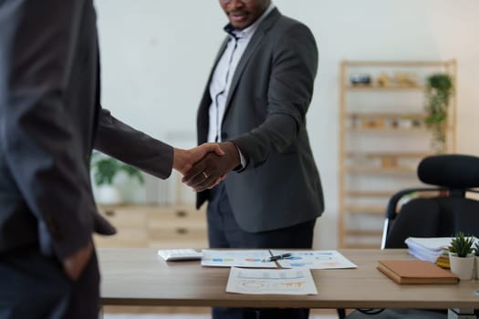 african american and asian people hand shaking successful corporate partnership deal welcoming opportunity in office agreement professional greeting meeting colleagues partners.