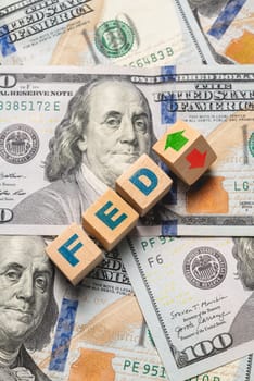 Wooden cubes with FED and up-down arrows over 100 usd. Fed rate hike concept to curb inflation