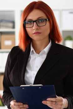 Portrait of businesswoman in glasses in business suit with clipboard. Beautiful woman business consultant manager