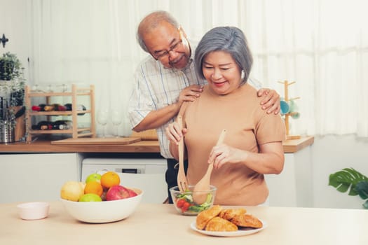 Contented senior couples who are happy to cook together with bread veggies and fruit in their kitchen.