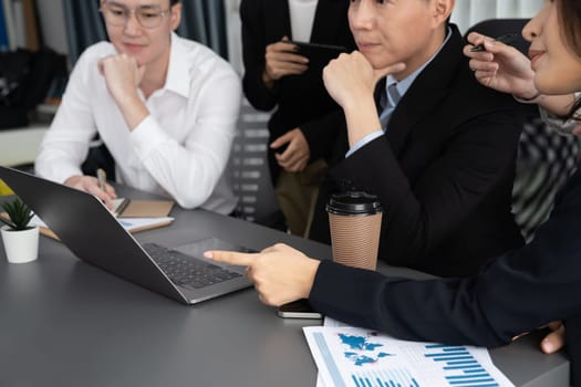 Harmony in office concept as business people analyzing dashboard paper together in workplace. Young colleagues give ideas at manager desk for discussion or strategy planning about project.