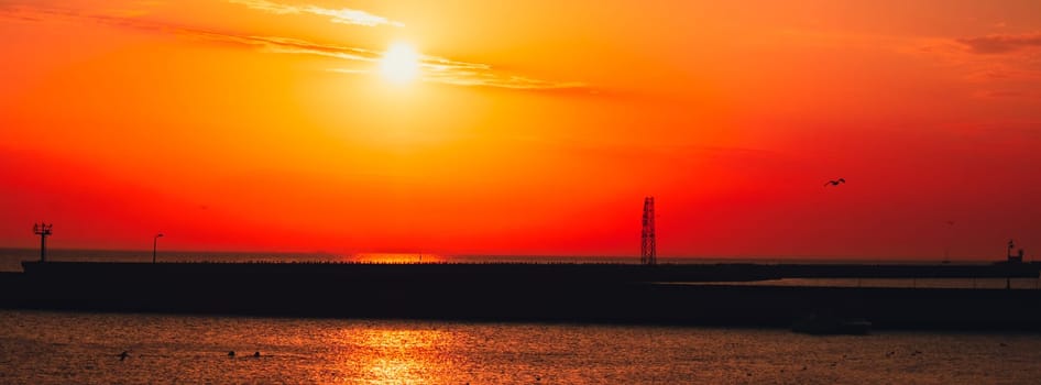 Reflection of sunlight over sea surface at sunset. Orange and gold blue sky. Scenic Gold sea. Dramatic Yellow sun coming out of the sea. Majestic summer landscape