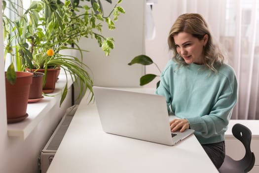 Side view head shot smiling mixed race lady freelancer wearing headset, communicating with client via video computer call. Millennial pleasant professional female tutor giving online language class.