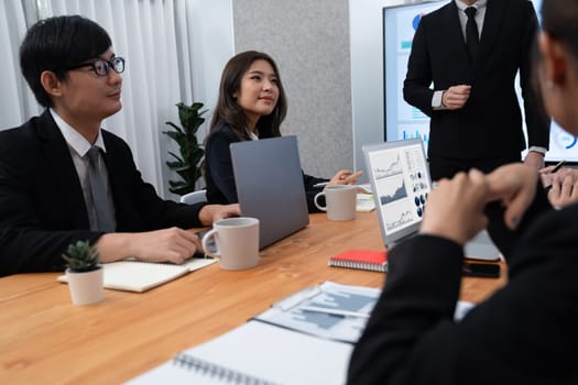 Confidence and asian businessman give presentation on financial analyzed by business intelligence in dashboard report to other people in board room meeting to promote harmony in workplace.