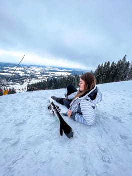 Shot of a skier woman sitting on the ski slope resting relaxing extreme recreation active lifestyle activity. Female skier on a slope in the mountains. Winter active sport Country cross skier in Alps