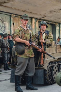 Hel, Poland - August 2022 Military troops marching during 3 May Polish Constitution Day ceremonial patriotic parade. Polish armed forces tanker military parade. Old guns and cars. Feast of Polish Armed Forces Day, American soldiers with US flag on parade Nato Vehicles Military Equipment