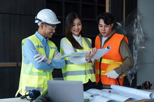 Team of engineer and architects working, meeting, discussing, designing, planning, measuring layout of building blueprints at construction site, Construction concept.