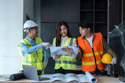 Team of engineer and architects working, meeting, discussing, designing, planning, measuring layout of building blueprints at construction site, Construction concept.