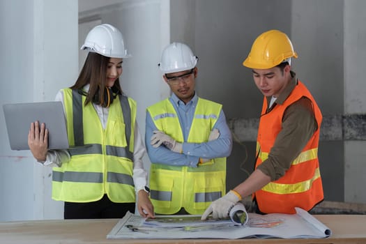 Team of engineer and architects working, meeting, discussing, designing, planning, measuring layout of building blueprints at construction site, Construction concept.