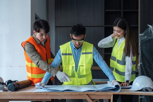 Team of engineer and architects working, meeting, discussing, designing, planning, measuring layout of building blueprints at construction site, Construction concept.