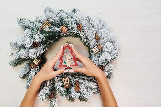 Woman's hands holds toys. Top view of christmas festive texture with new year decorations.