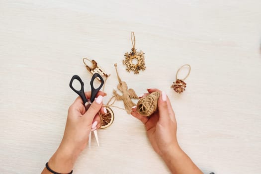 Woman's hands holds toys. Top view of christmas festive texture with new year decorations.