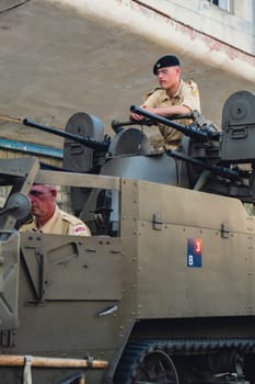 Hel, Poland - August 2022 Military troops marching during 3 May Polish Constitution Day ceremonial patriotic parade. Polish armed forces tanker military parade. Old guns and cars. Feast of Polish Armed Forces Day, American soldiers with US flag on parade Nato Vehicles Military Equipment