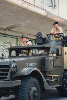 Hel, Poland - August 2022 Military troops marching during 3 May Polish Constitution Day ceremonial patriotic parade. Polish armed forces tanker military parade. Old guns and cars. Feast of Polish Armed Forces Day, American soldiers with US flag on parade Nato Vehicles Military Equipment