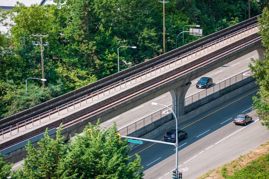 Modern cityscape. Fragment of four lane asphalt road with skytrain path above