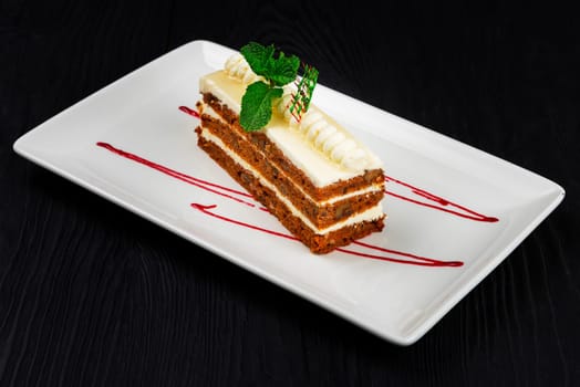 Chocolate cake decorated with mint leaves on black background