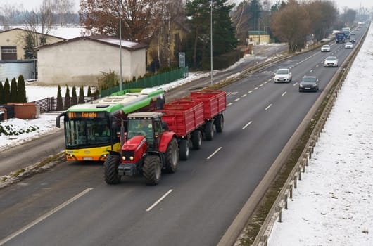 Poznan, Poland - January 24, 2023: Car traffic on a motorway in Poland. A bus and a tractor are driving in the foreground.