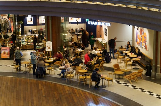 Poznan, Poland - February 4, 2023: People in Starbucks coffee in a mall.