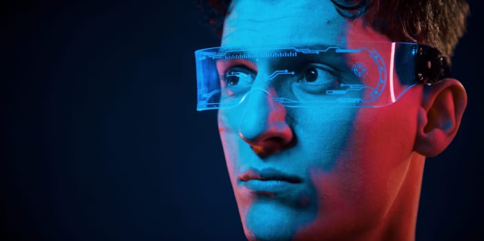 Close up portrait. Neon lighting. Young european man is in the dark studio.