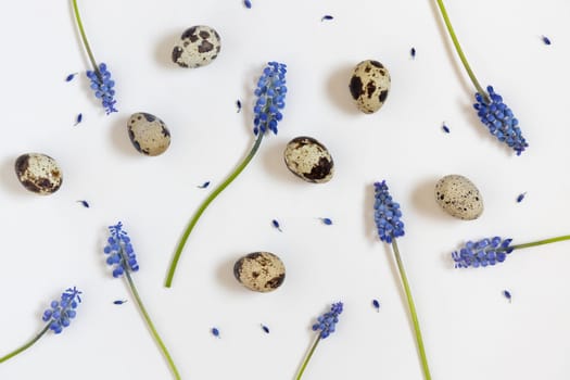 Easter eggs and blue flowers pattern. White background. Happy easter concept, flat lay, copy space